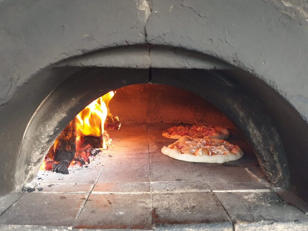 Wood-fired Pizza baking in oven